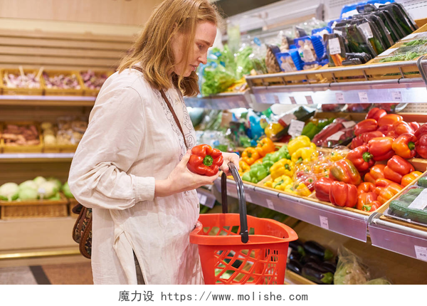 在超市买菜的年轻女人在超级市场买金发碧眼的年轻女人